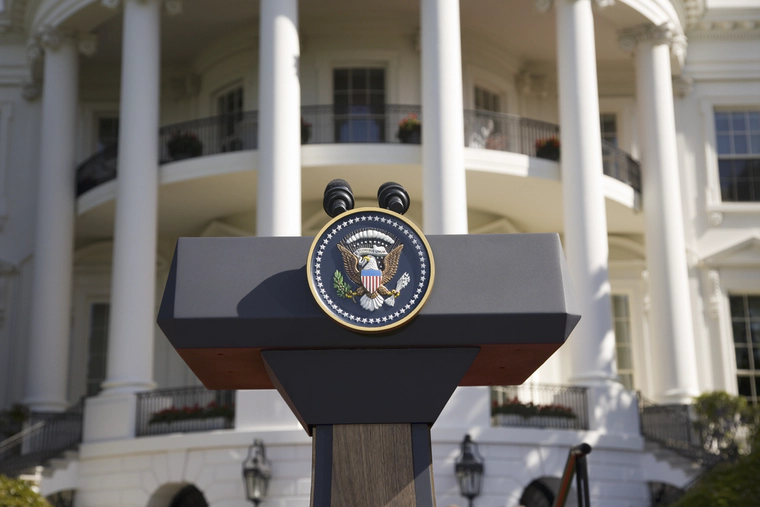 Podium with the president USA seal in front of the White House 
