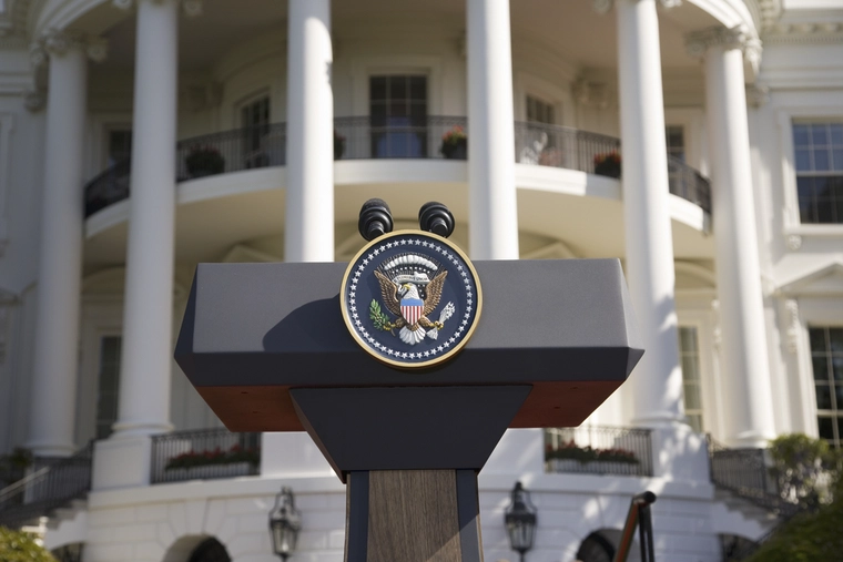 Podium with the president USA seal in front of the White House 