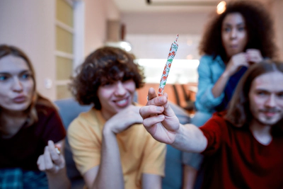Young adults look at marijuana joint