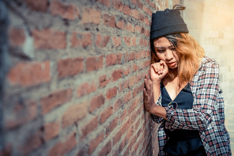 Teenager sitting by the wall
