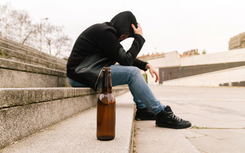 Editorial Image Man on steps with bottle in foreground