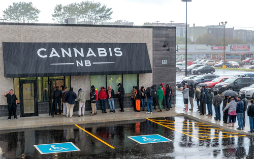 Crowd lined up in the rain outside of dispensary